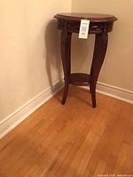full view of accent table showing shape, legs and lower shelf