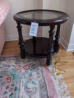 Overall view of dark cherry round end table beside sofa