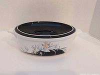Side view showing floral Black Rhapsody pattern and black lid on casserole
