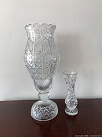 Front view of both crystal vases showing overall form and size comparison