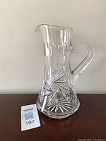 Front view of clear cut crystal pitcher showing pinwheel cuts and flared base
