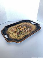 Oblique view of rectangular hand-painted tole tray showing handles and painted surface