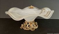 Side view showing ruffled opalescent glass bowl and ornate base
