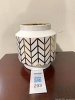 Front view of white ceramic vase with gold chevron pattern