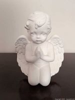 Front view of white porcelain kneeling cherub angel figurine