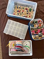 Overview of plastic boxes, fabric pieces, floss container and ribbon basket