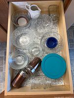 Drawer view showing glass bowls, mason jar, shakers, creamer and ramekin
