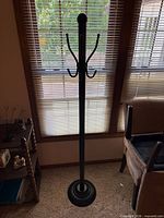 full view of black metal coat rack in front of window