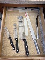 Knife set in drawer showing three knives, honing steel and guards