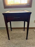 Full view of closed wooden sewing cabinet