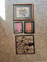 All four art pieces laid out on carpet