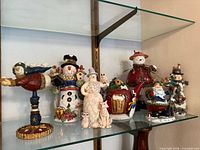 Full group of resin holiday figurines on glass shelf