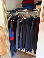 Closet view showing multiple sweatshirts, polo shirts and jeans