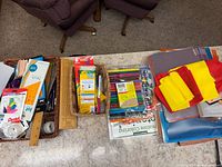 Overview of baskets containing stationery, art markers, colored pencils, rulers, resistance bands, folders