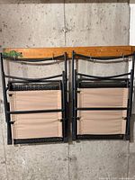 Both chairs folded and hanging, showing frames and beige backs