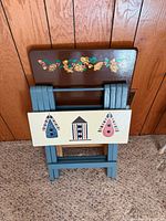 Both folded trays leaning against paneling showing painted tops