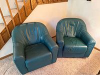 Front top view of both teal faux leather club armchairs side by side