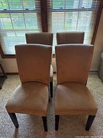 Front view of all four beige microfiber dining chairs