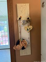 Full view of vertical crackle-paint wall board with bunny figurine and notepad