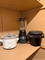 Three countertop appliances: slow cooker, blender, deep fryer