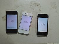 Front view of three Apple iPhone 4s powered on to setup screen