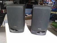 Front view of both Aiwa bookshelf speakers on table