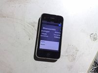 Front view of black Apple iPhone powered on at setup screen