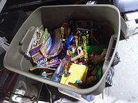 Overview of grey bin filled with loose LEGO pieces and booklets
