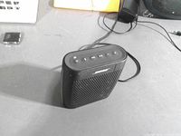 Front angled view of black Bose SoundLink Color speaker showing grille and side profile