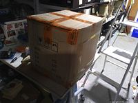 Closed cardboard shipping carton showing external condition and shipping labels