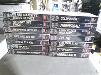 Stacked spines of 14 sealed James Bond VHS tapes showing titles