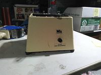 Back of beige Wiz glass grinder showing logo, on-off switch and housing condition