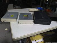 Front view of three optical drives: two internal (beige, silver) and one black external