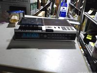 Front view showing LED clock display, cassette door, speaker grille and control buttons