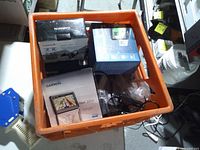 Top-down view of crate showing boxed and loose Garmin GPS units and accessories