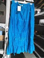 Full view of long blue tiered skirt on hanger