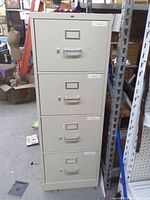 Full view of beige 4-drawer filing cabinet with handles and label slots