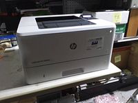 Front and left side view of HP LaserJet Pro M402n printer on table