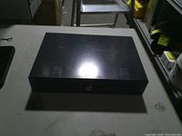 Closed black metal lockbox on table