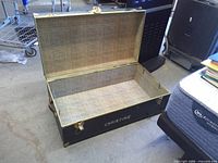 Trunk open showing interior woven fabric lining
