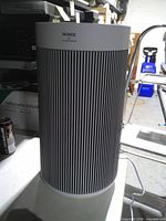 Front view of Winix cylindrical air purifier showing brand and grille