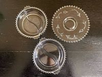 Top view of three Candlewick glass pieces showing etched designs and divisions