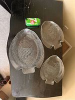large glass fish platter with two smaller matching plates beside soda can for scale
