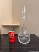 Full decanter beside soda can for scale