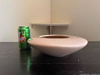 Side view showing planter profile beside 7-Up can for scale