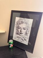 Full view of framed Marilyn Monroe pencil portrait with 7-Up can for scale