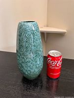 Front view of the vase next to Coke can for scale