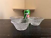 Side view showing three clear pebble textured bowls