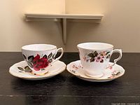 Front view of the two matched teacup and saucer sets