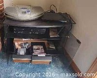 Overall lot showing boombox on top of table with media below